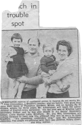 Start of image description, A newspaper clipping from 1958 features an image of a young Adrian, aged around 1 year old, in the arms of his mother. His sister, Hilary, is being held by his father. The accompanying text begins “Newspaper reports of continued unrest in Cyprus do not worry Mr Fred Edmondson, a Bradford teacher, and his family. This week they leave their home at Plumpton Gardens, Wrose, and on Sunday fly to Nicosia where, for three years, Mr Edmondson will teach the junior children of English army personnel.” end of image description