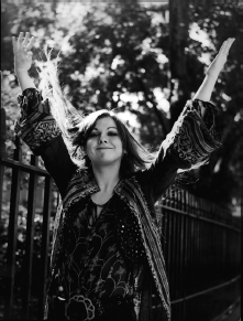 Start of image description, Sonja Kristina, the lead singer of Curved Air. Sonja is pictured smiling beside the railings of a park, her arms held aloft., end of image description