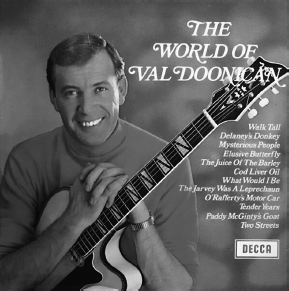 Start of image description, The record cover of Val Doonican’s 1969 album, The World of Val Doonican. A grinning Doonican, wearing a turtleneck, sits holding his guitar. The track listing reads Walk Tall, Delaney’s Donkey, Mysterious People, Elusive Butterfly, The Juice of the Barley, Cod Liver Oil, What Would I Be, The Jarvey was a Leprechaun, O’Rafferty’s Motor Car, Tender Years, Paddy McGinty’s Goat and Two Streets., end of image description