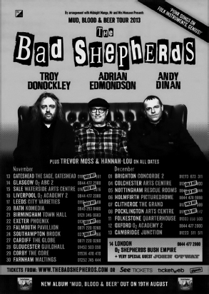 Start of image description, A poster for The Bad Shepherds’ Mud, Blood, and Beer tour in 2013. The poster features Adrian, Troy Donockley and Andy Dinan sitting on a sofa. A quote reads, Funk songs on folk instruments. Genius! The poster features the list of gig dates from Gateshead to Cardiff to Brighton to Pocklington., end of image description
