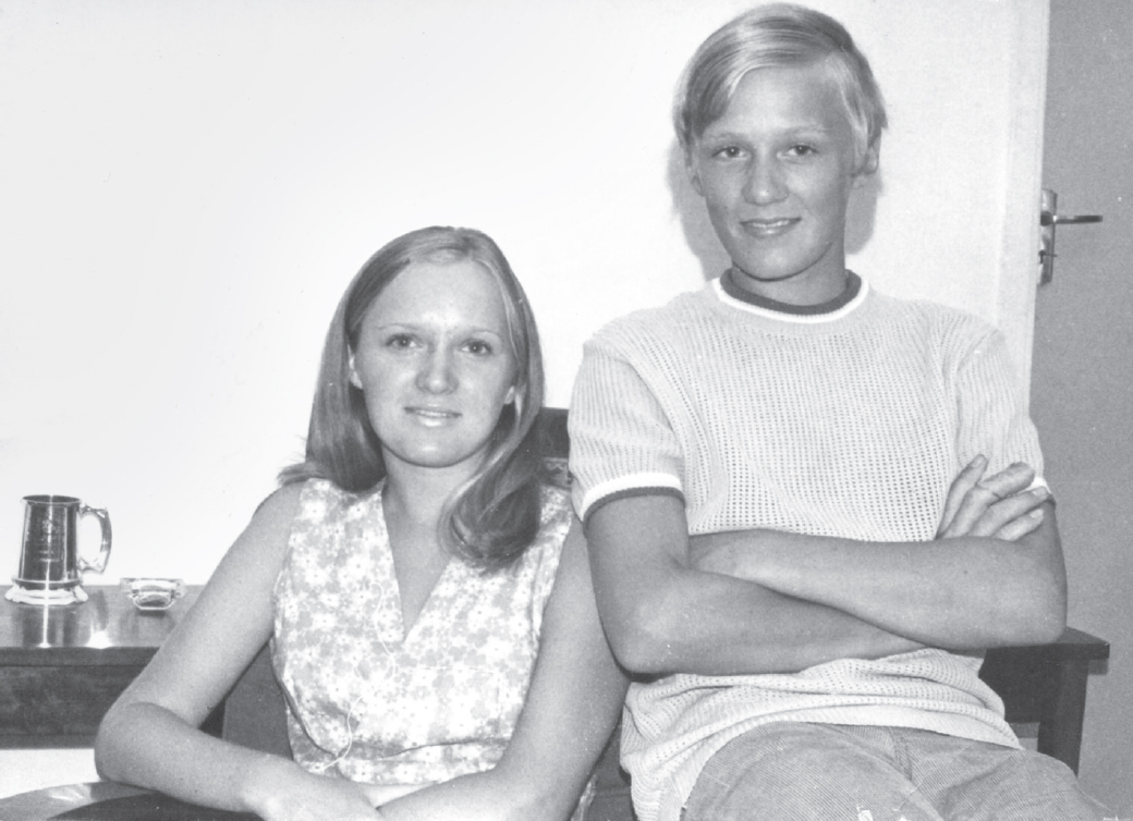 Start of image description, Adrian poses with his sister Hilary in 1972. She is 18 and he is 15 years old. He is perched, arms folded, on the arm of the chair she is sitting in., end of image description